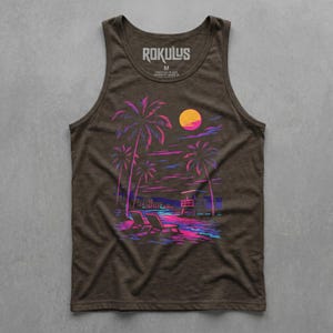 May include: Brown vest top featuring a neon beach scene graphic. The design includes palm trees, a lifeguard station, and sun loungers in pink, purple, and blue. The brand name "ROKULUS" is printed at the top. The image evokes a retro aesthetic.