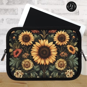 May include: A black zippered case with a sunflower print. The case is designed to hold a tablet or laptop. The print features yellow sunflowers, green leaves, and red and orange flowers.