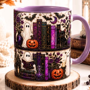 May include: A ceramic mug with a purple interior and handle, featuring a wrap-around illustration of ghosts, jack-o'-lanterns, black cats, and stacks of books in shades of purple, black, and gold against a cream-colored background.