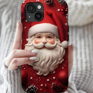 May include: A smartphone case featuring a festive red background with a central illustration of Santa Claus wearing a red hat with white trim. The design includes scattered white snowflakes, red ornaments, and brown pinecones across the surface.
