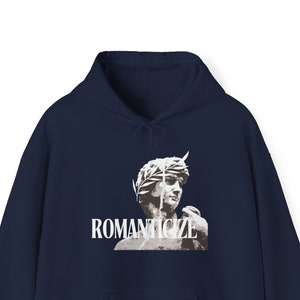 May include: A navy blue hoodie with a white graphic of a statue wearing a crown and the word "ROMANTICIZE" printed below.