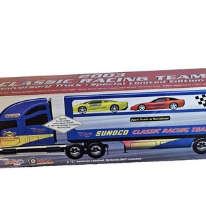 May include: A blue, yellow, and red toy truck box with the text "2003 Classic Racing Team". The box features a truck with a trailer carrying two toy race cars. The box also has the text "10th Anniversary Truck".