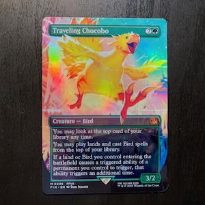 May include: A holographic trading card featuring a yellow bird, the "Traveling Chocobo," with outstretched wings. The card has text that reads "Creature - Bird" and other game instructions. The card's background is a mix of rainbow colors.