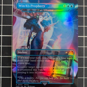 May include: A holographic trading card titled "Witch's Prophecy" with the text "Force of Negation." The card features an illustration of a woman in a dark dress with a feathered collar, set against a backdrop of blue and white. The card includes game instructions.