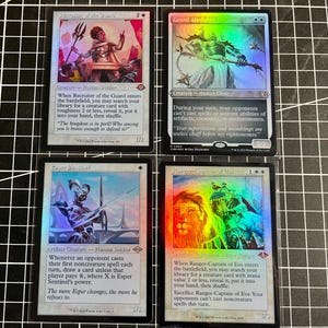 May include: Four Magic: The Gathering trading cards arranged in a grid. The cards are Recruiter of the Guard, Grand Abolisher, Esper Sentinel, and Ranger-Captain of Eos. Each card features detailed fantasy illustrations, text, and holographic foil.