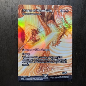 May include: A holographic trading card featuring the "Dragon of Mount Gulg." The card depicts a detailed illustration of a dragon with a humanoid figure. Text includes "Creature - Elder Dragon" and game instructions. The card's power/toughness is 6/5.