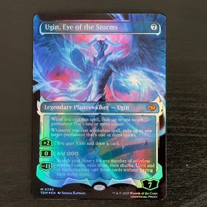 May include: A Magic: The Gathering card featuring Ugin, Eye of the Storms. The card is a legendary planeswalker with a blue, white, and red background. The card text reads: "When you cast this spell, exile up to one target permanent that's one or more colors. Whenever you cast a colorless spell, exile up to one target permanent that's one or more colors. +2: You gain 3 life and draw a card. 0: Add OOO. -11: Search your library for any number of colorless nonland cards, exile them, then shuffle. Until end of turn, you may cast those cards without paying their mana costs."