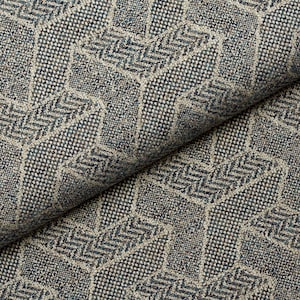 Peut inclure: Gros plan sur un tissu texturé avec un motif géométrique. Le tissu présente un motif répétitif de formes imbriquées dans des tons de gris, beige et bleu. Le tissage est visible, ajoutant de la profondeur et de la dimension au textile.