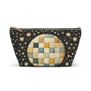 Peut inclure: Une pochette noire à fermeture éclair avec une bordure blanche et un grand motif circulaire de courtepointe patchwork sur un fond noir avec des étoiles dorées.