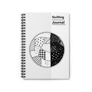 May include: A white spiral-bound notebook with the text "Quilting Journal" in black. The cover features a black and white patchwork design in a circular shape, with various patterns like stars and stripes.