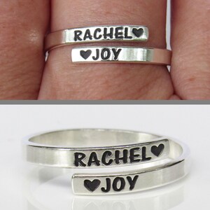 May include: A silver ring with two bands, one inscribed with "RACHEL&hearts;" and the other with "&hearts;JOY".