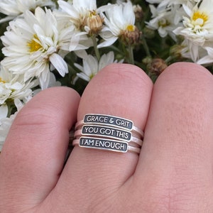 Pictured is the plate rings stacked together. The GRACE & GRIT inspirational ring is pictured here with the YOU GOT THIS and I AM ENOUGH rings as well.