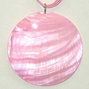 May include: A pink iridescent shell pendant necklace with a round, smooth, and shiny surface. The pendant is attached to a thin cord.