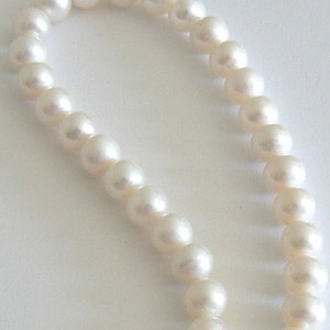 May include: A strand of white pearls strung together in a necklace.