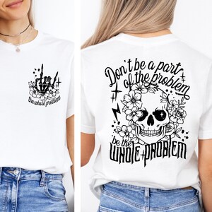 May include: White t-shirt with a skull and flowers graphic on the back. The text on the back reads "Don't be a part of the problem, be the whole problem". The front of the shirt has a smaller graphic of a hand with the middle finger extended and the text "the whole problem".