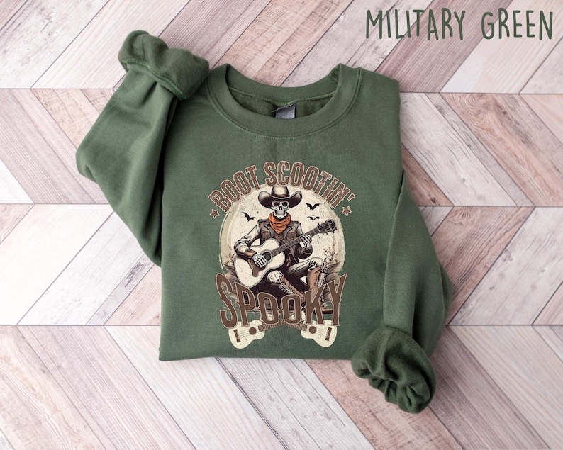 May include: A green sweatshirt with a skeleton playing a guitar and the text "Boot Scootin' Spooky" printed on the front.