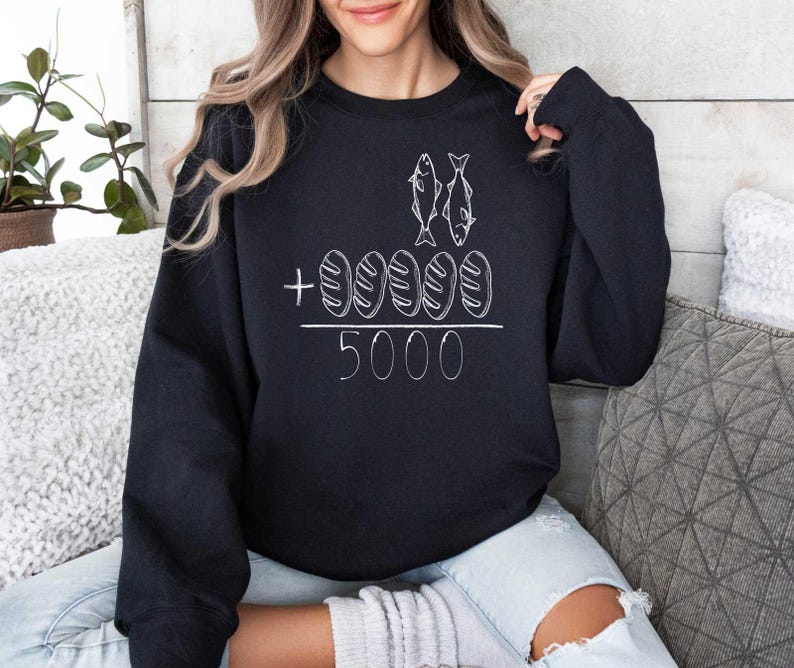 May include: Black sweatshirt with a white graphic of two fish and five loaves of bread with the text " + 5000".