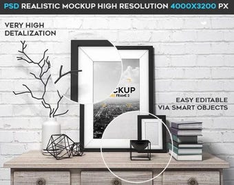 May include: A black picture frame mockup with a white mat and a cityscape image inside. The frame is on a wooden table with a vase, a geometric sculpture, and a small bowl. The background is a white brick wall. The text "EASY EDITABLE VIA SMART OBJECTS" is visible in the image.