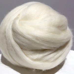 May include: A large ball of white wool fiber. The wool is soft and fluffy, and it is perfect for spinning or felting.