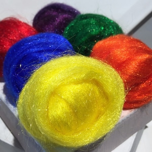 May include: A collection of six colorful yarn balls in red, blue, yellow, green, and purple. Each ball is made of a soft, fluffy material with a sparkly finish.