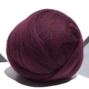 May include: A ball of deep burgundy wool roving, perfect for felting projects.