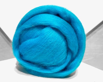 Könnte beinhalten: Eine Kugel türkisblauer Wollroving. Die Wolle ist weich und flauschig und perfekt zum Filzen oder Spinnen.