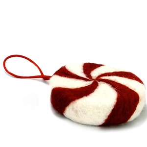 May include: A red and white peppermint candy ornament made of felt with a loop for hanging.