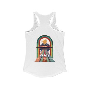 May include: White racerback tank top with a retro graphic featuring a UFO, sun, and rainbow arch. The design includes the year "2027" and the text "THE YEAR EVERYTHING CHANGES" in a vintage style. A casual, comfortable top.