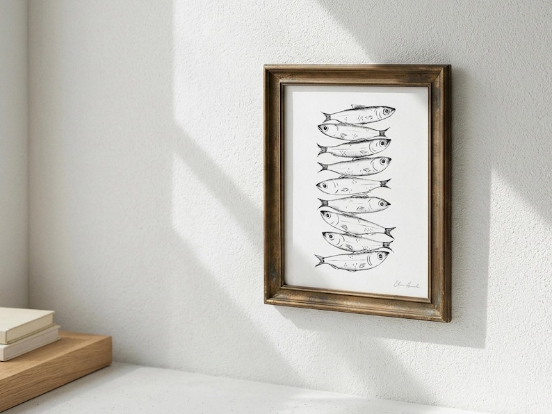 Puede incluir: Una pieza de arte mural enmarcada que presenta una ilustraci&oacute;n en tinta negra y blanca de una pila vertical de ocho peces. La obra est&aacute; encerrada en un marco de madera marr&oacute;n oscuro con un perfil cl&aacute;sico, mostrando el detallado trazo de los peces.