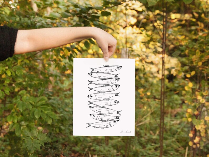 Nine whimsical sardines in a vertical line, each swimming in a different direction, line drawing print with moody, storybook, cottagecore style. Kitchen Decor Sardine print.