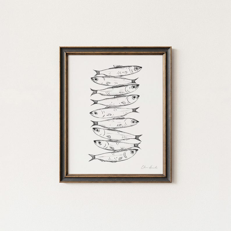 May include: Black framed art print featuring a stack of sardines. The sardines are illustrated in black and white, with detailed lines depicting their scales and fins. The artwork is signed in the bottom right corner.