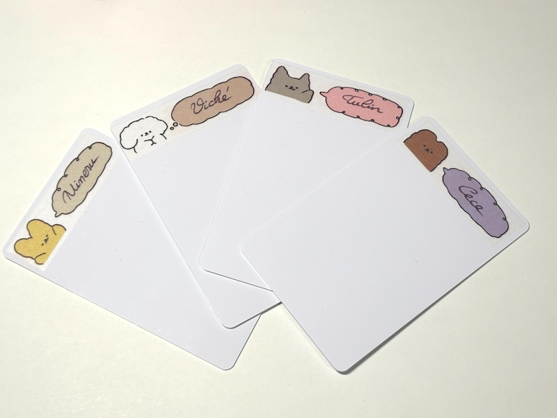 May include: Four white rectangular cards with rounded corners. Each card has a different cartoon animal and name in a speech bubble. The animals are a yellow bear, a white dog, a gray cat, and a brown bear. The names are "Minoru", "Vich&eacute;", "Tulin", and "Cece".