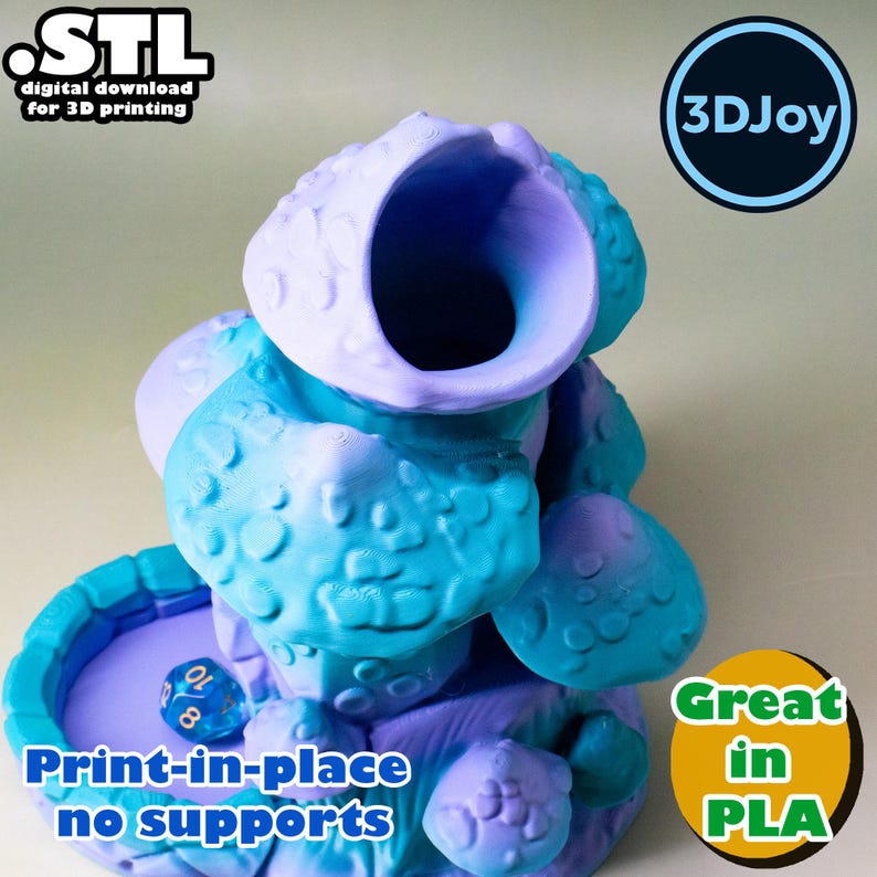May include: A 3D-printed, multi-colored dice tower in shades of blue and purple. The tower has a unique, organic design with a large opening at the top. The text "Print-in-place no supports" is visible. The tower is designed for 3D printing.