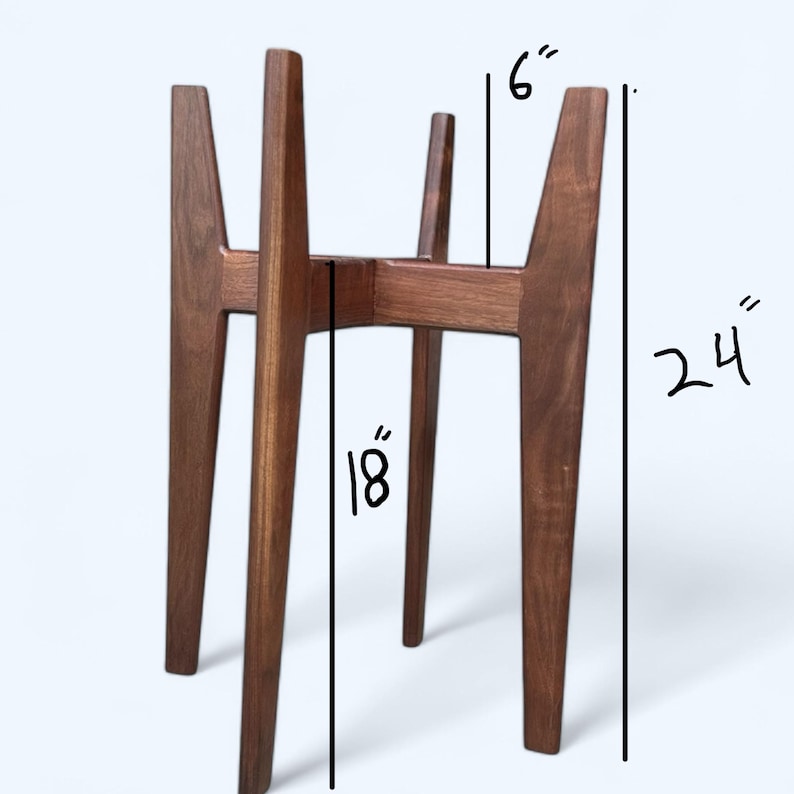 May include: A wooden plant stand with a mid-century modern design. The stand is brown and has four angled legs. It is 24 inches tall, 18 inches wide, and 6 inches deep.