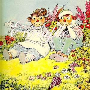May include: Two rag dolls with red yarn hair and painted faces are sitting in a field of flowers. The dolls are wearing colorful clothing and are smiling.