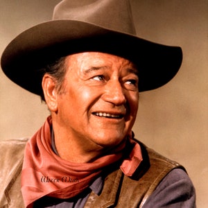 May include: A portrait of a man wearing a brown cowboy hat, a red scarf, and a brown leather vest. The man is smiling and looking off to the side. The background is a solid tan color.