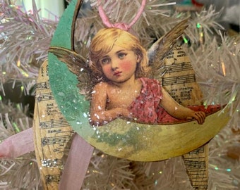 ANGEL sitting on the moon with sheet music wings.*Ribbon wrapped hanger*Seam binding ribbon streamers*German glitter