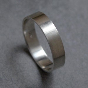 May include: A simple silver band ring with a brushed finish.