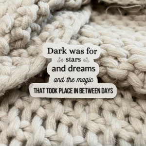 May include: White sticker with black text that reads "Dark was for stars and dreams and the magic THAT TOOK PLACE IN BETWEEN DAYS".