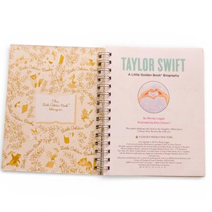 May include: Open Little Golden Book biography of Taylor Swift. The cover features the title in green and a heart-shaped hand gesture illustration. The inside cover has a gold floral pattern and the text "This Little Golden Book belongs to".