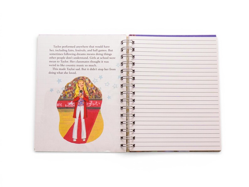 May include: Open spiral notebook with lined pages and a colorful illustration. The illustration depicts a blonde woman in a red coat and white pants holding a microphone on a stage. Text on the left page describes the woman's journey.