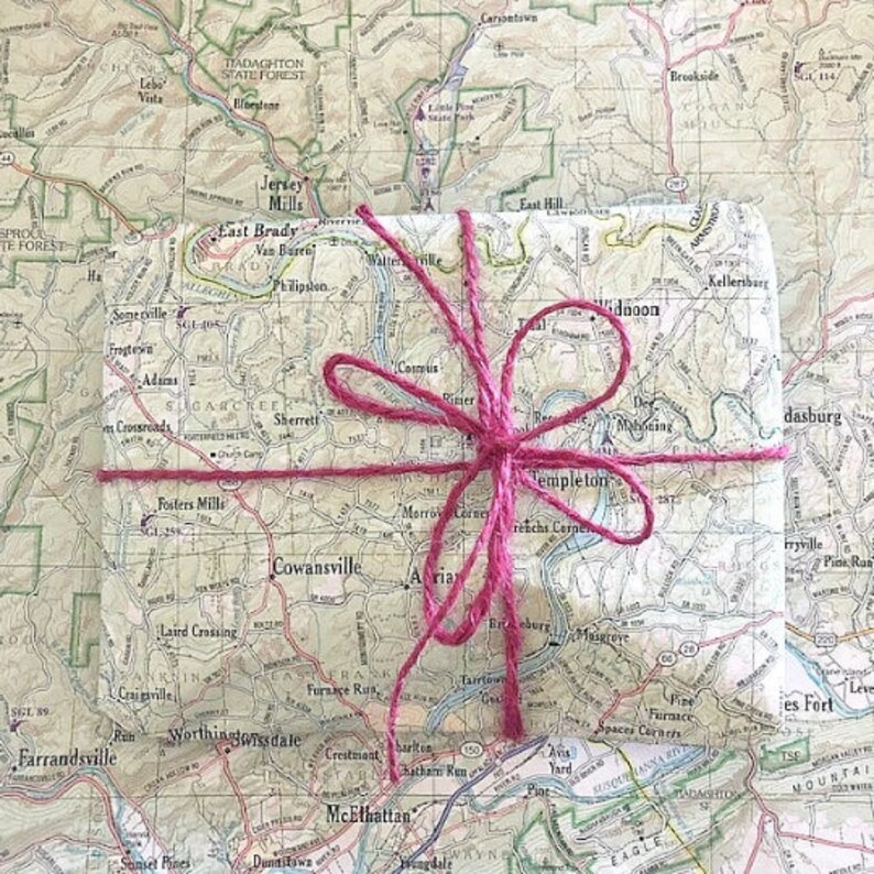 May include: A small, square package wrapped in a vintage map with a pink ribbon tied around it. The map shows the area around Cowansville, Maryland.