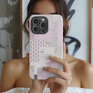 Puede incluir: Una funda de teléfono de patchwork en tonos rosa, blanco y gris. El diseño incluye elementos florales, geométricos y de texto. El texto en la funda dice "Salmo 37:5" y una cita. La funda tiene un recorte para la cámara.