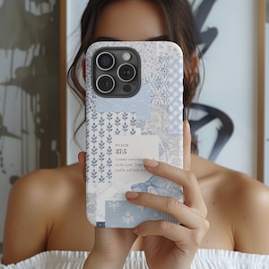 May include: A light blue and white patterned phone case with a floral and patchwork design. The case features the text "PSALM 37:5" and a quote. The case has a camera cutout and is held in front of a person.