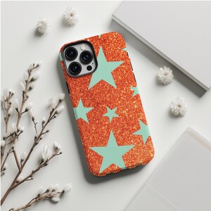 May include: A phone case featuring a glittery orange design with light blue star shapes. The case has a camera aperture and is likely made of a protective material. The design is modern and visually appealing.