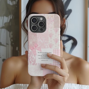 May include: A pink and white patchwork phone case with a bow and text from Matthew 6:34. The case features floral and gingham patterns. The phone case is designed to fit a smartphone.