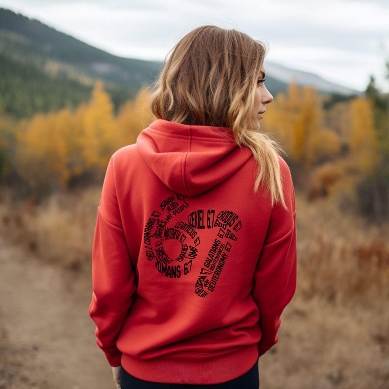 May include: A red hoodie with a hood and long sleeves. The back of the hoodie features a black graphic design with the text "Ezekiel 6:7" and other biblical references arranged in a circular pattern. The hoodie is made of a soft material.
