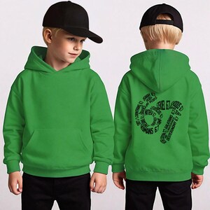 May include: A green hooded sweatshirt with a front pocket and a black baseball cap. The back of the sweatshirt features black text in a circular design, including the words "Ezekiel 67" and other biblical references.