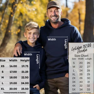 May include: Two people wearing navy blue hoodies, with a size chart for the Gildan 18500 Hoodie. The chart shows measurements in inches, with sizes ranging from XS to 5X. The hoodies have a front pocket and a hood.