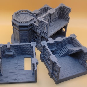 May include: A gray, 3D-printed modular dungeon building set featuring stone brick walls, a fireplace, a staircase, and an octagonal tower section. The set consists of three separate, interlocking pieces with detailed floor textures and open doorways.